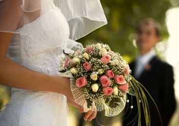 groom looks on the bride holding a bouquet.